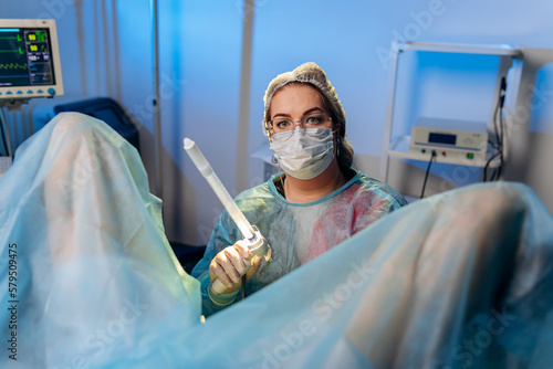 Fotografie Professional female surgeon proctologist performing operation using special devices for colonoscopy in the operating room in hospital