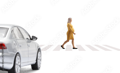 Car waiting and a pregnant woman walking on a pedestrian corssing photo