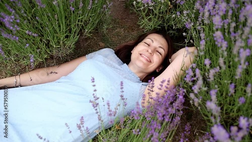 Harmony with nature. beautiful girl lies on a field of blooming lavender. happy girl inhales the fragrance of beautiful flowers. photo