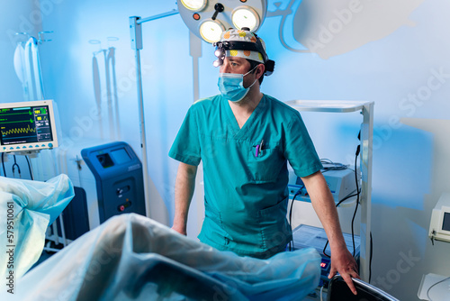 Professional male surgeon proctologist performing operation using special medical devices in the operating room in hospital. Urgent surgical concept