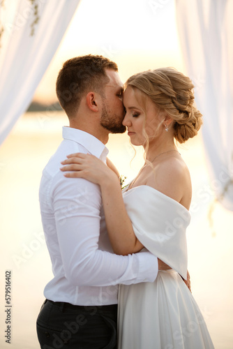 bride and groom against the backdrop of a yellow sunset