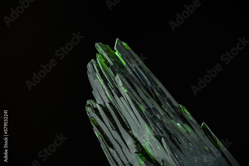 dark green aegirine crystal on black background. macro detail texture background. close-up raw rough unpolished semi-precious gemstone photo