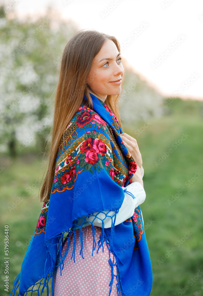 Portrait of a beautiful woman in a blue headscarf. Spring garden Portrait of a beautiful woman in a blue headscarf. Spring garden