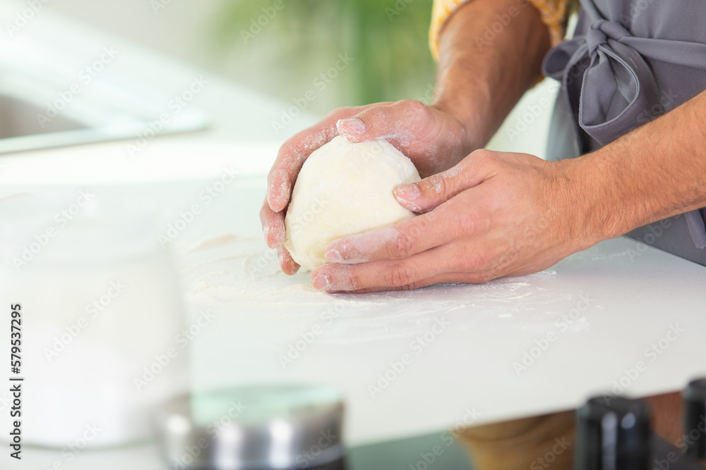 hands holding dough on floured work surface hands holding dough on floured work surface
