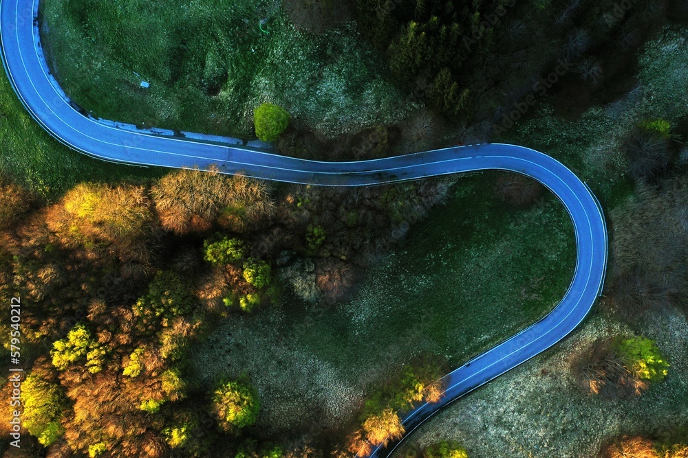 Aerial road: Scenic curvy road seen from a drone in autumn, view from above. Road in the forest. Road in the woods. Sassalbo, Emilia Romagna, Italy