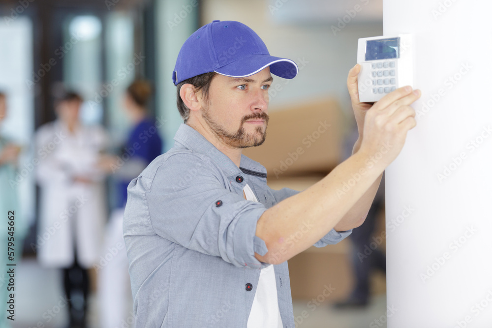 men regulate temperature on control panel of central heating men regulate temperature on control panel of central heating