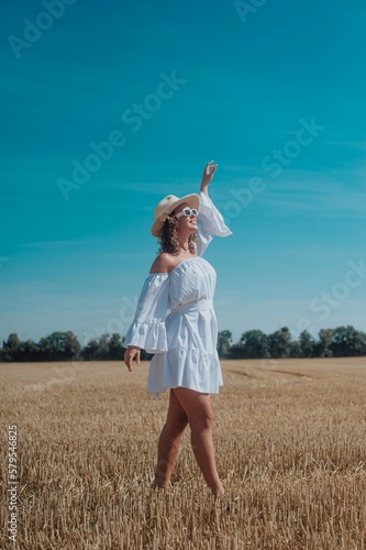 Fototapeta Naklejka Na Ścianę i Meble -  woman in white sunglasses posing outdoors in a beautiful dress
