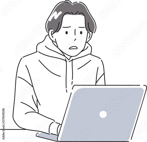 困った表情でノートパソコンを操作する男性