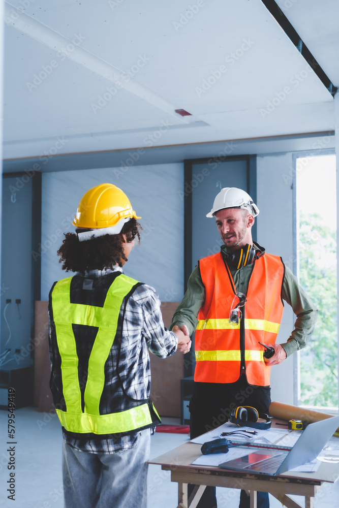 Group of multi ethnic engineer construction site worker meeting at workplace, Architects working together at construction site to remodeling home or building. Shaking hands Group of multi ethnic engineer construction site worker meeting at workplace, Architects working together at construction site to remodeling home or building. Shaking hands