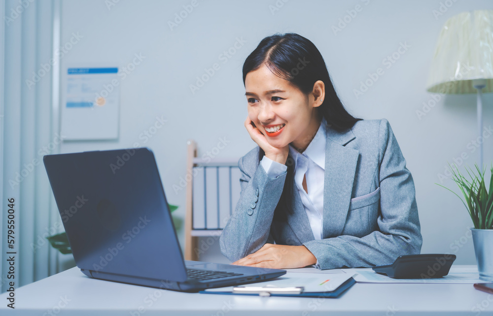 Young Asia business woman working with annual summary report and laptop to planner analyze data of balance sheet charts, bookkeepers female people concept. Using laptop Young Asia business woman working with annual summary report and laptop to planner analyze data of balance sheet charts, bookkeepers female people concept. Using laptop
