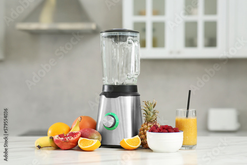 Tasty smoothie, blender and ingredients on white marble table