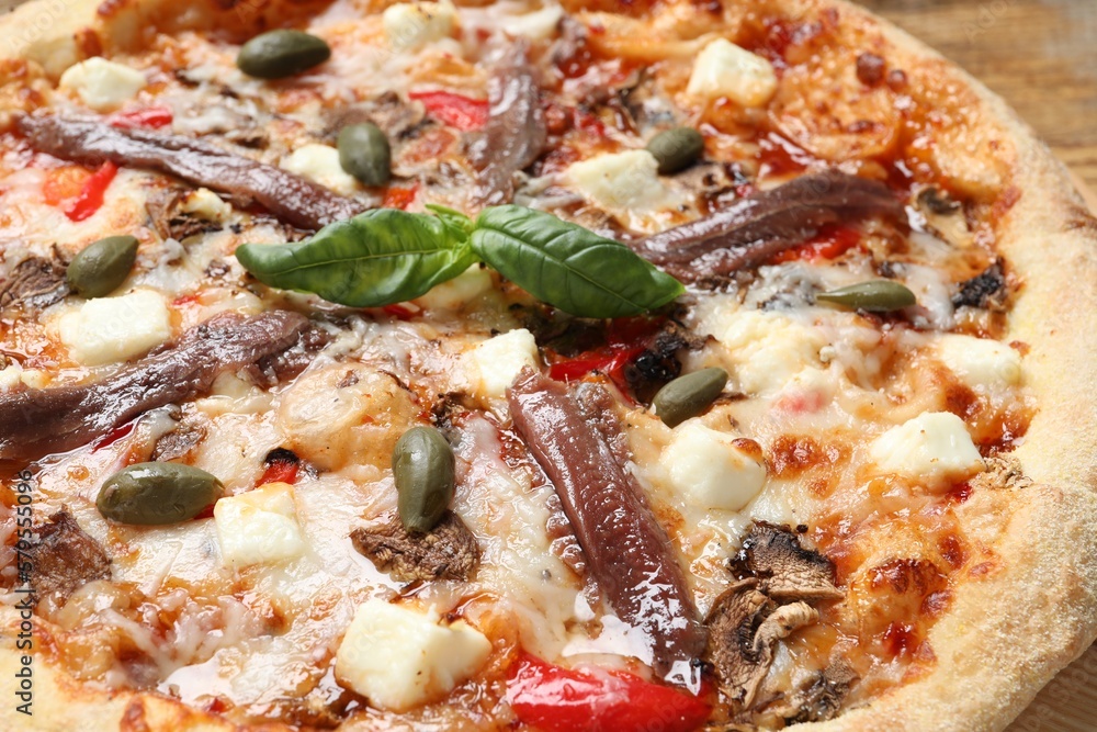 Tasty pizza with anchovies, basil and olives on wooden table, closeup Tasty pizza with anchovies, basil and olives on wooden table, closeup