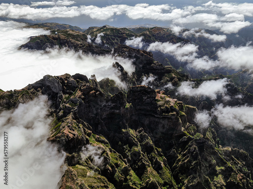 Stone peaks of mountains among the clouds, top view from a drone.