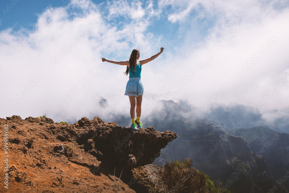 Woman tourist standing on a cloudy mountain peak, Portugal, Madeira. Woman tourist standing on a cloudy mountain peak, Portugal, Madeira.