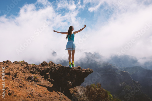 Woman tourist standing on a cloudy mountain peak, Portugal, Madeira.