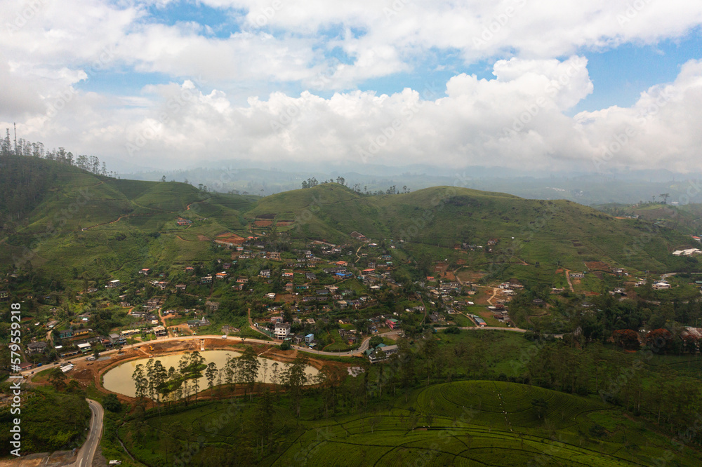 Top view of village among tea plantations. Houses of farmers growing tea. Tea estate landscape. Maskeliya.
