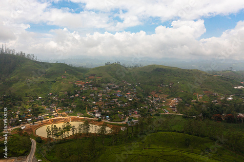 Top view of village among tea plantations. Houses of farmers growing tea. Tea estate landscape. Maskeliya.