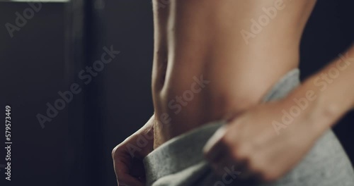 Fit, healthy and toned womans stomach muscles after training her ab exercises during her fitness workout routine in the gym. Athletic female shows her sexy, desirable and alluring body in a close up photo