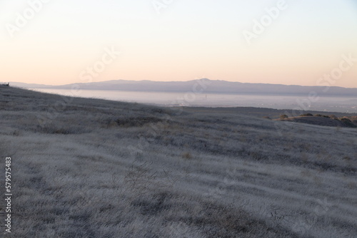 Beyond the golden grasses of summer lie views of Salinas valley and Monterey Bay in Central California photo