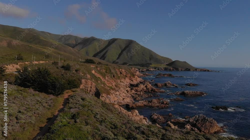Hiking path along coastal highway one near rocky coastline during sunset. Hiking path along coastal highway one near rocky coastline during sunset.