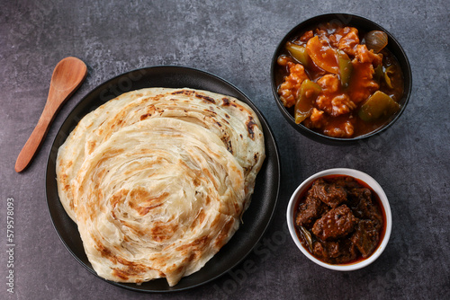 Kerala parathas porotta roti parotta barotta naan layered flatbread made from maida or whole wheat flour. Eat with spicy Asian chicken chili chicken beef curry gravy. breakfast dish. Indian food.