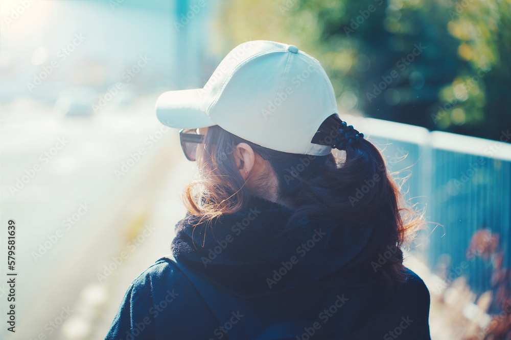 帽子を被った女性の後ろ姿 Photos | Adobe Stock