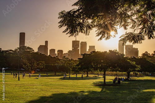 Fototapeta Naklejka Na Ścianę i Meble -  Afternoon scene of the new farm park and urban skyline from afar in golden hours in Brisbane