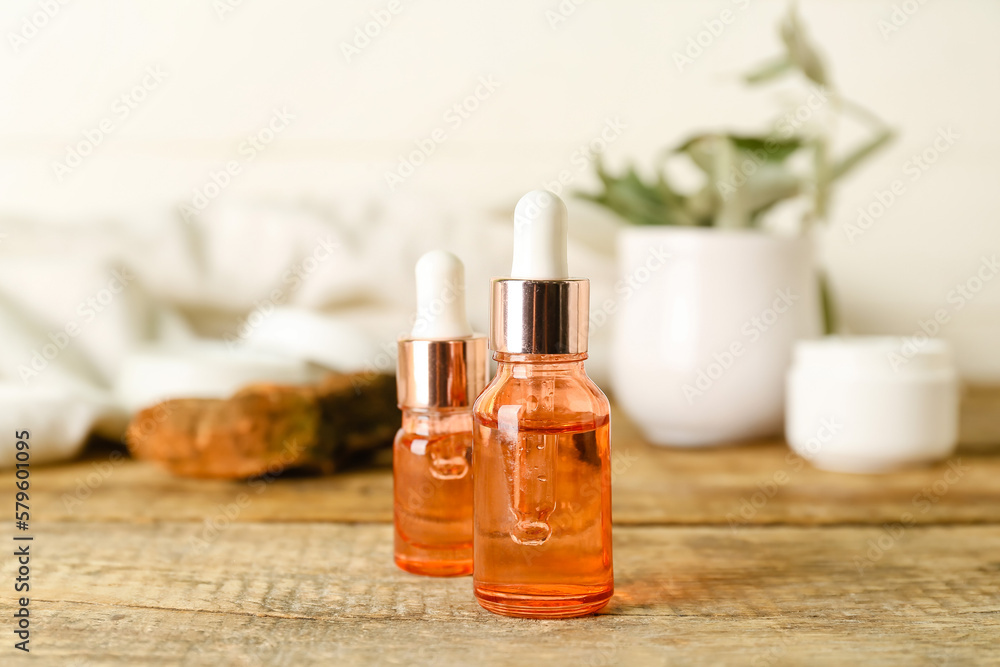 Bottles of olive essential oil on wooden table Bottles of olive essential oil on wooden table
