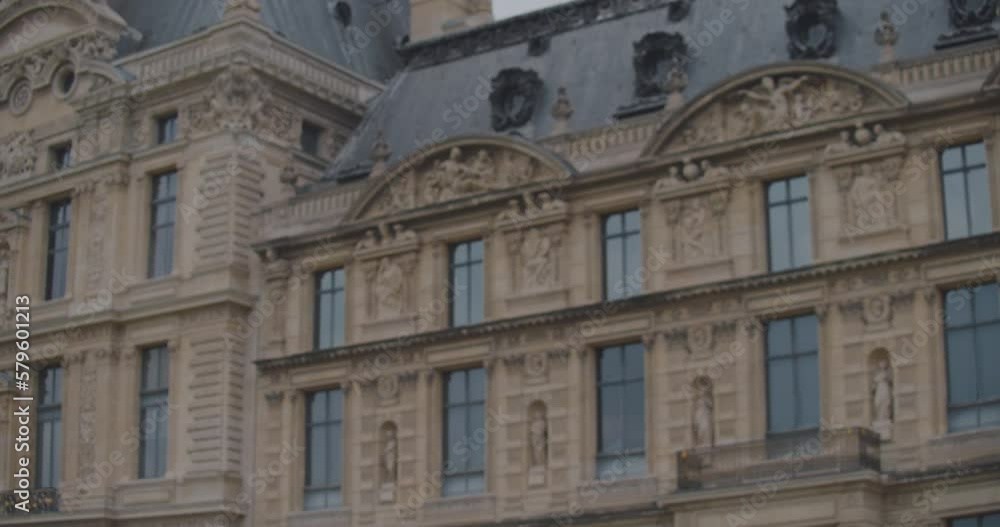 Blonde girl in coat doing ballet leap in front of old Parisian building. Close up Blonde girl in coat doing ballet leap in front of old Parisian building. Close up