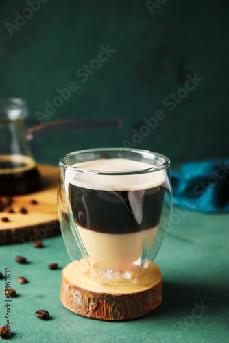 Glass of tasty Cafe Bombon on color background