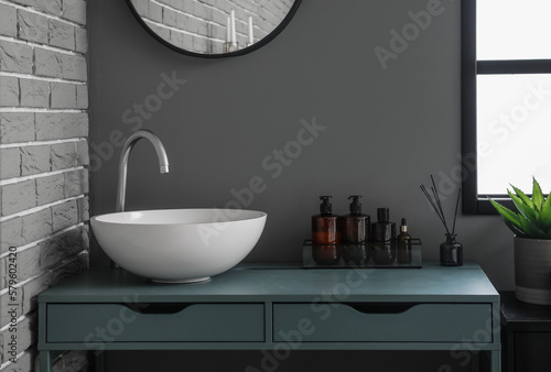 Table with sink and bath accessories in modern bathroom