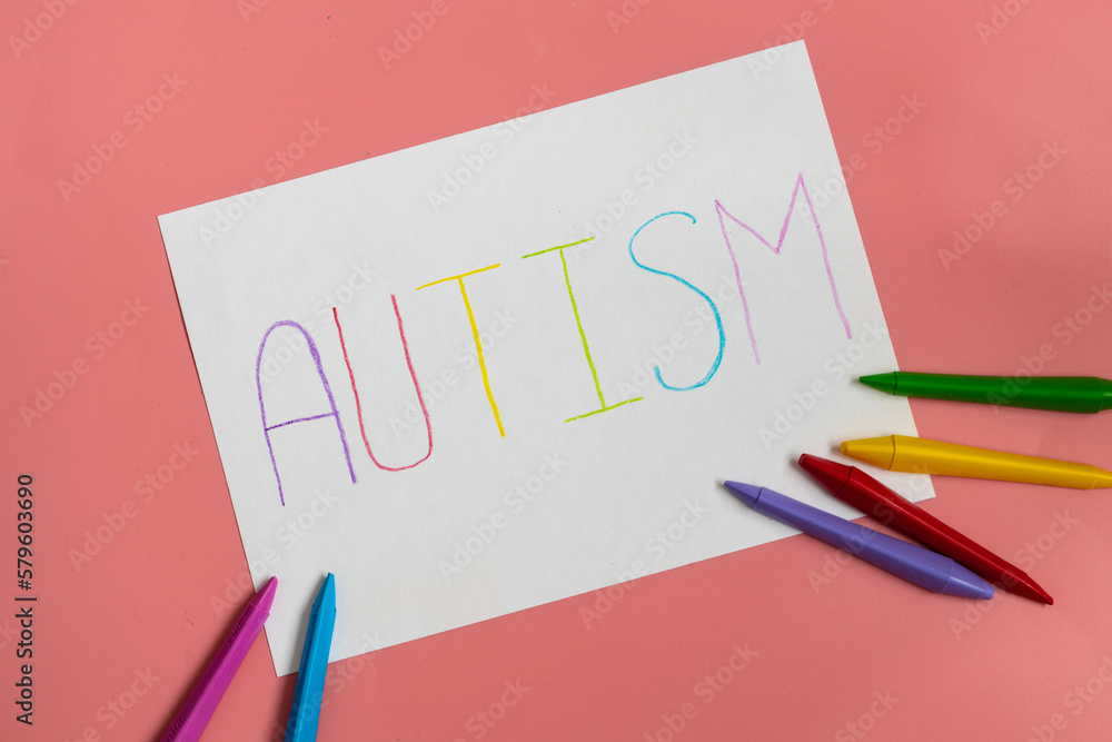 Text word autism on paper sheet written by colorful letter, on blue background. Text word autism on paper sheet written by colorful letter, on blue background.
