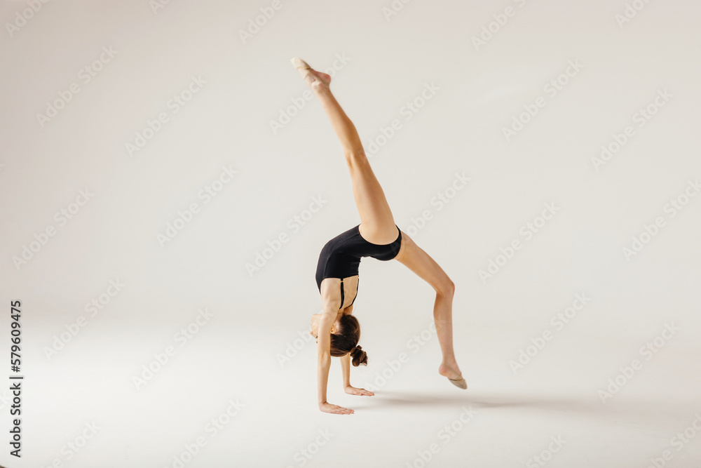 Girl gymnast performs a jump to the top. Girl gymnast performs a jump to the top.