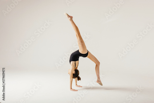 Girl gymnast performs a jump to the top.