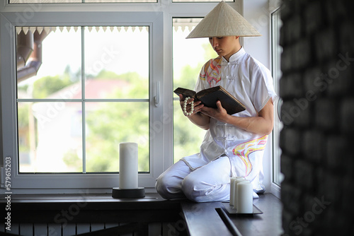 Asian boy in kimono reading an old book
