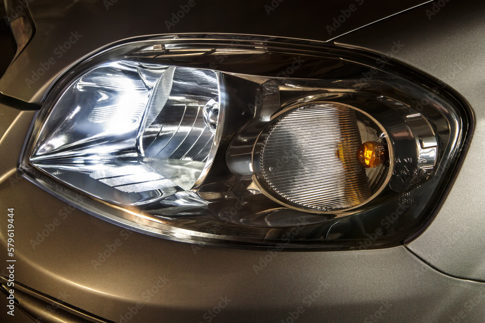 Headlight on. The headlight of a passenger car. The headlight of the car. Headlight close-up.