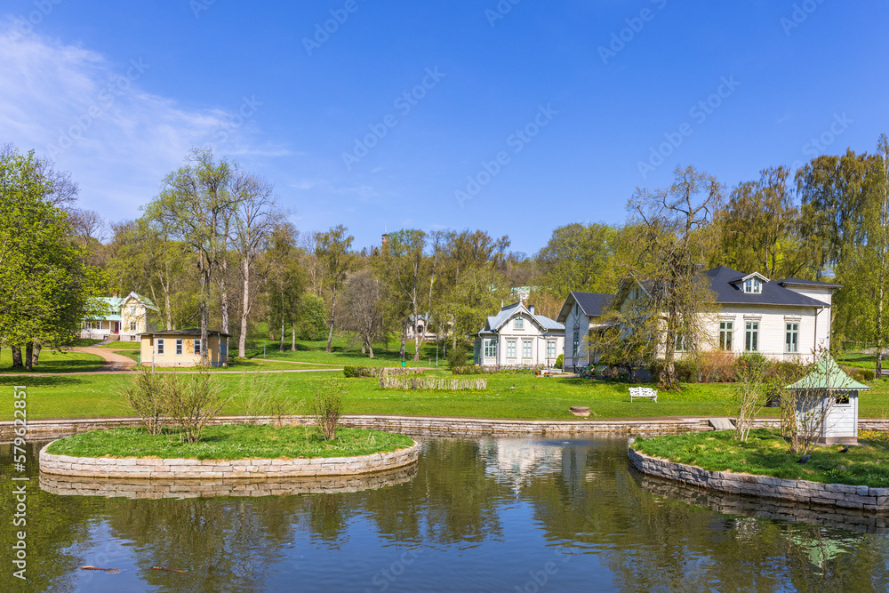 Old idyllic houses by a pond in a park