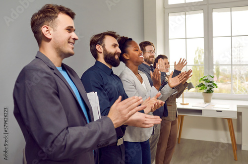 Принти на полотні Multinational people working in same company applaud after performance or refresher training and participate in team building activities stand in office along wall