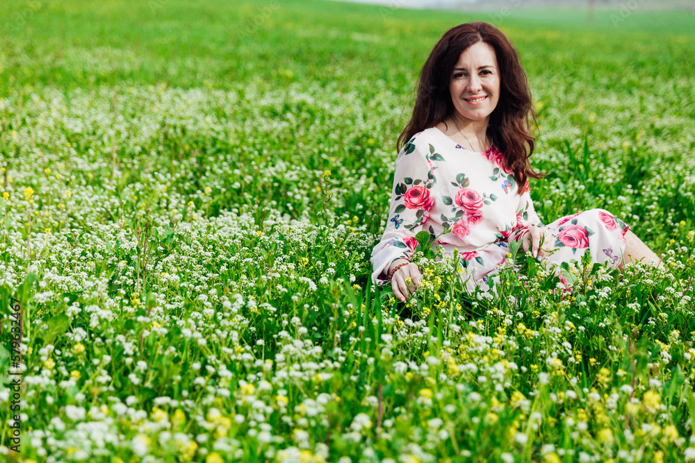 a beautiful woman sitting in a green clearing in nature a beautiful woman sitting in a green clearing in nature