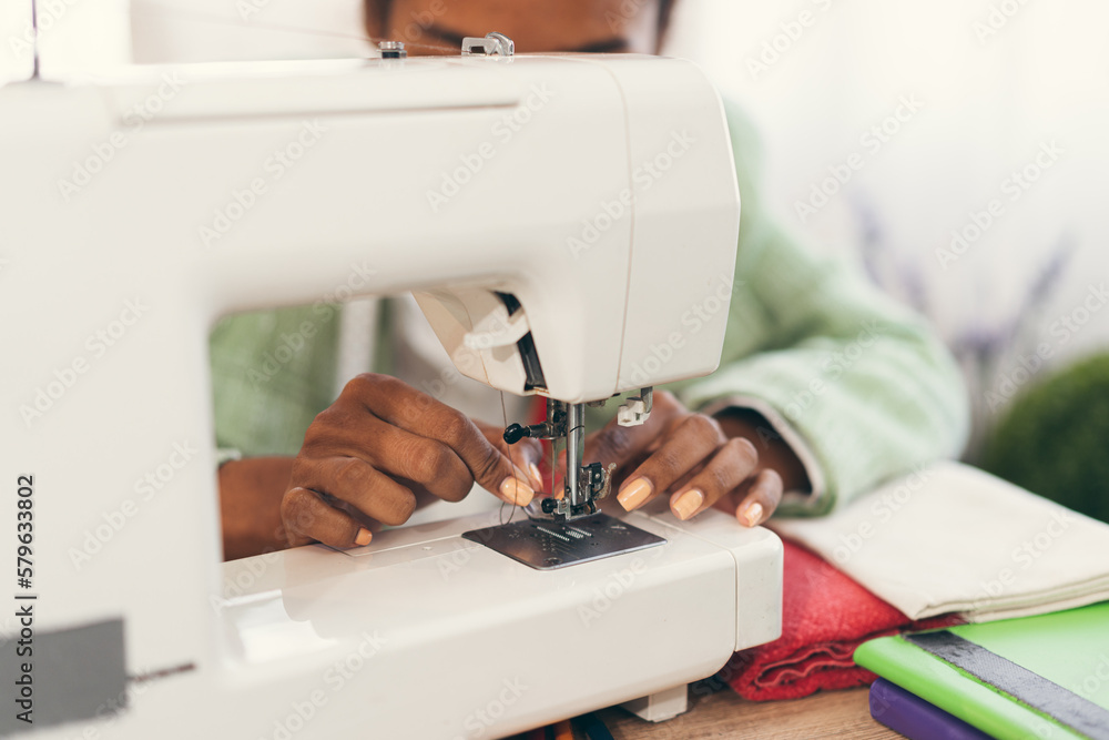 Hand African American woman fashion designer clothes working with sewing in own dressmaking studio or boutique	