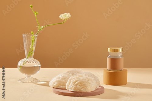 Some bird’s nests are placed on a round podium and a glass jar of bird’s nests soup standing on brown cylinder podium. Bird’s nest is one kind of beauty food for women. photo