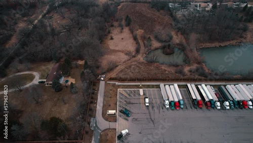 sideways aerial of  truck stop aerial view. Carhauler, dryvan, reefers, flatabed, bobtails parked. USA 4k Aerial photo