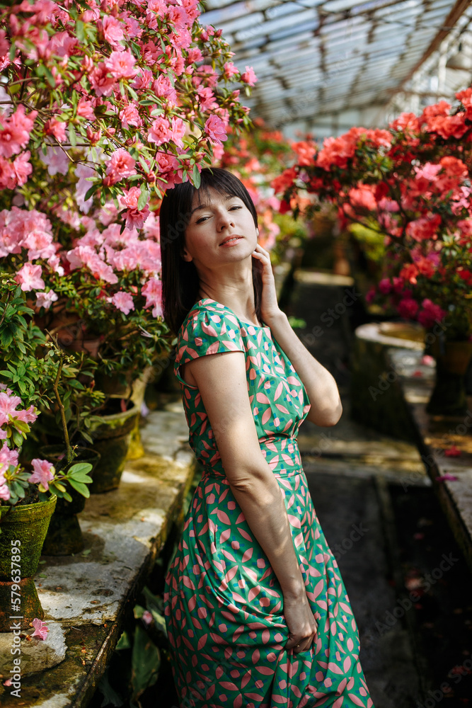 Beautiful girl in a green dress in a garden of blooming azaleas Beautiful girl in a green dress in a garden of blooming azaleas