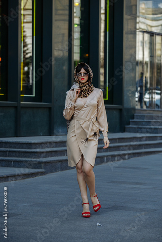 A girl in sunglasses walks the streets of the city © Andrii