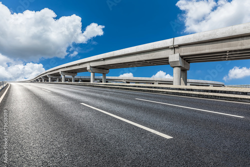 Empty asphalt road and viaduct under the blue sky