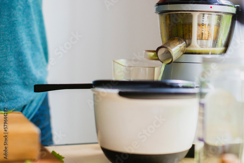 Arugula juice is being extracted from juicer in kitchen at home