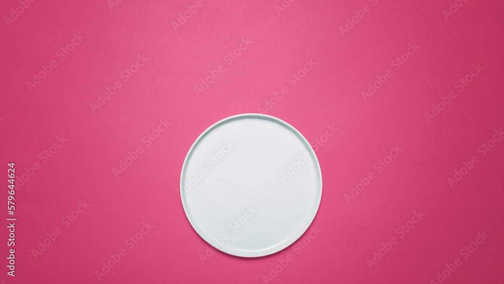 Overhead view of empty plate on pink background Overhead view of empty plate on pink background