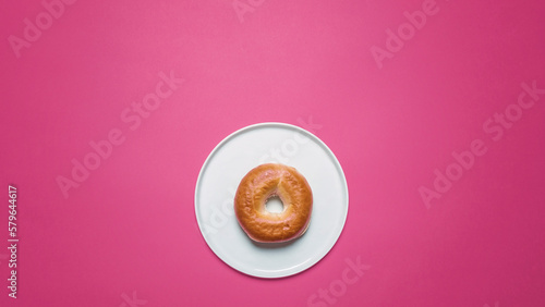 Overhead view of bun in plate on pink background photo