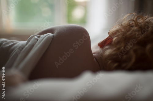 Rear view of baby boy sleeping on bed at home