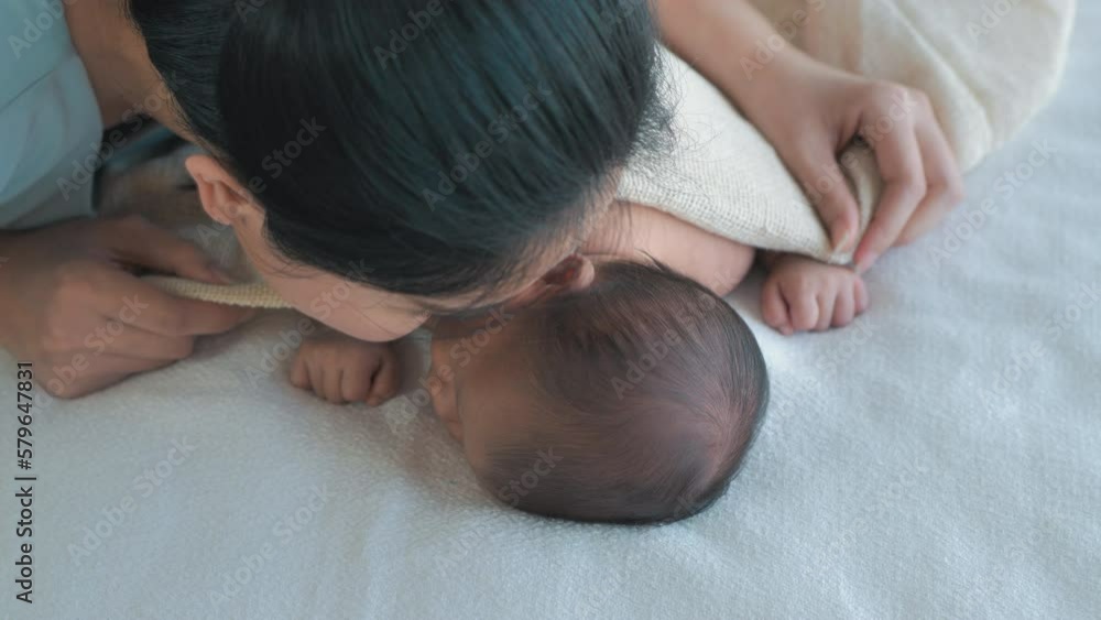 Mother puts on a blanket for her baby, Child Care Mother puts on a blanket for her baby, Child Care